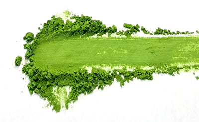 Trace de poudre de matcha d'un vert vif et éclatant sur fond blanc, signe d'un matcha de qualité